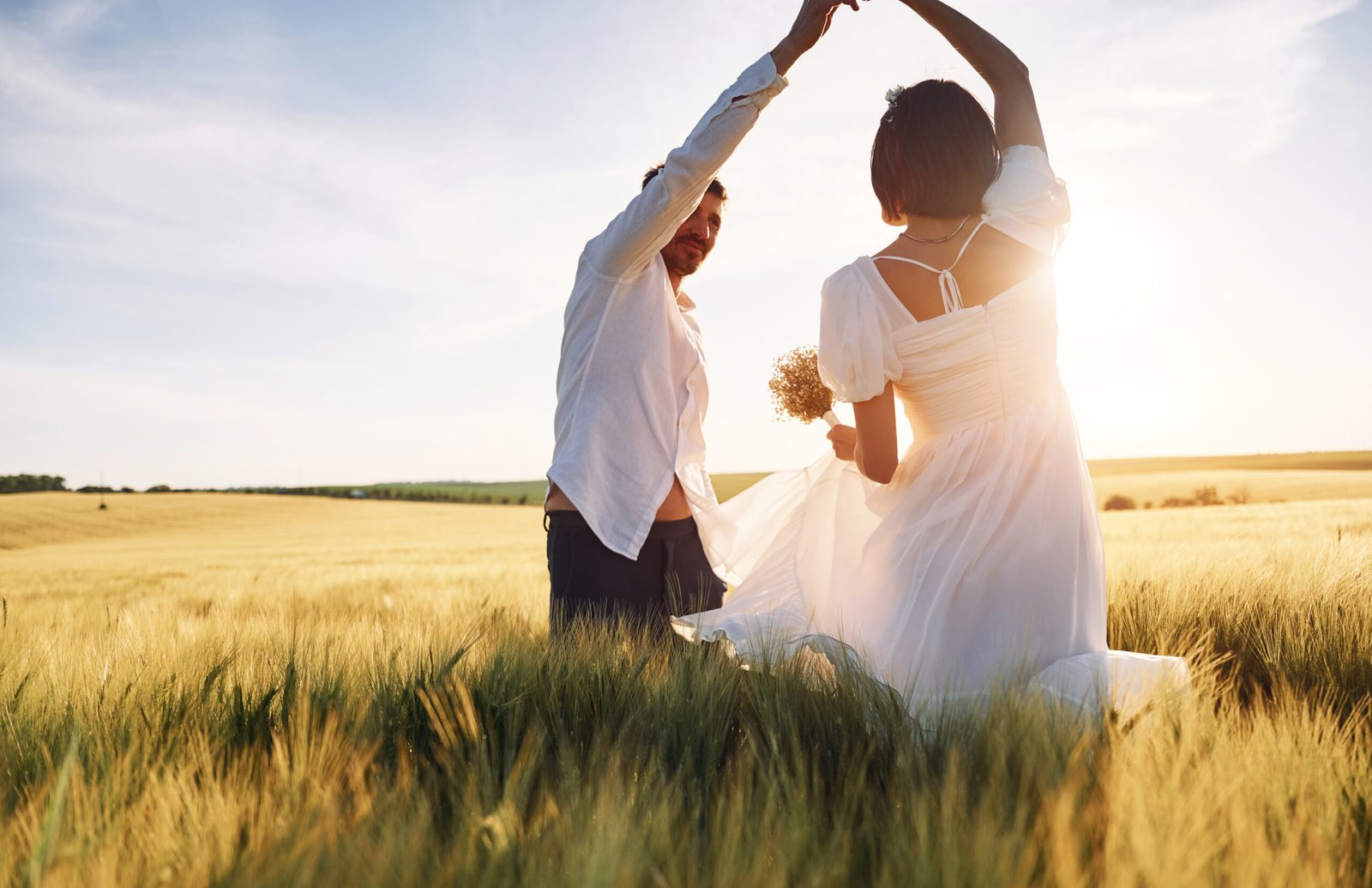 Newlywed couple backlit by golden sunlight, an example of photography style