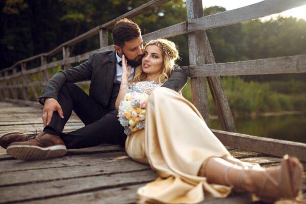 Stylish newlyweds posing in a park on their wedding day
