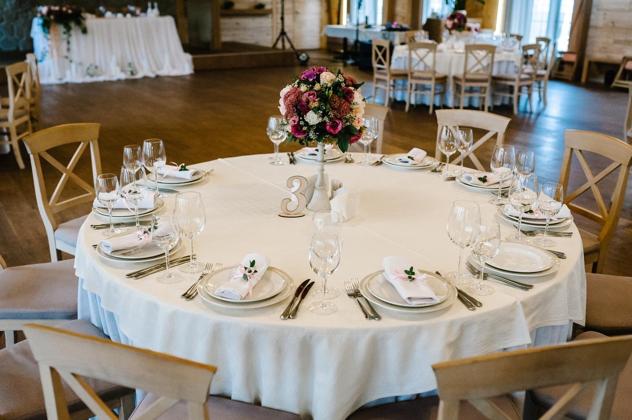 Wedding reception table setting with florals, glassware and place settings