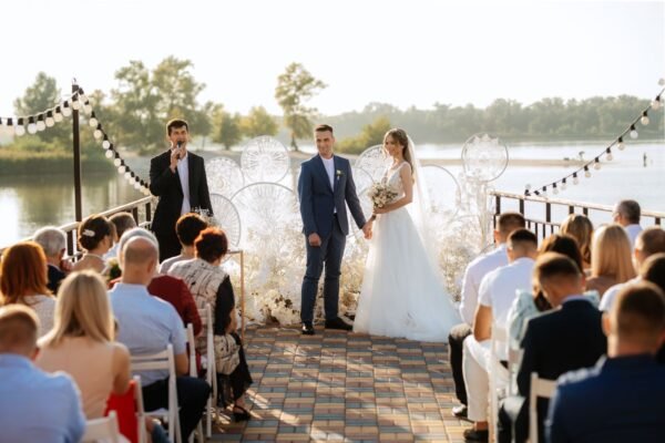 Outdoor lakeside wedding ceremony near Duluth at sunset with string lights